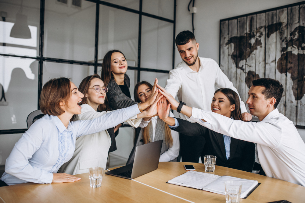 equipo de trabajo contentos por haber llegado  a meta empresarial del mes