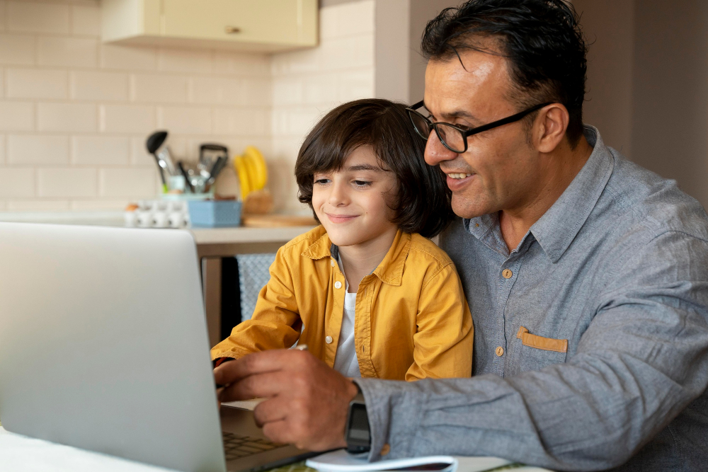 padre e hijo juntos manejando una laptop