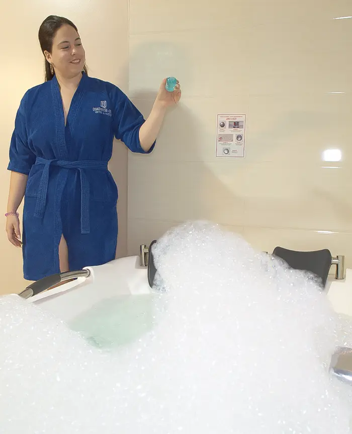 mujer echando liquido para burbujas en el jacuzzi
